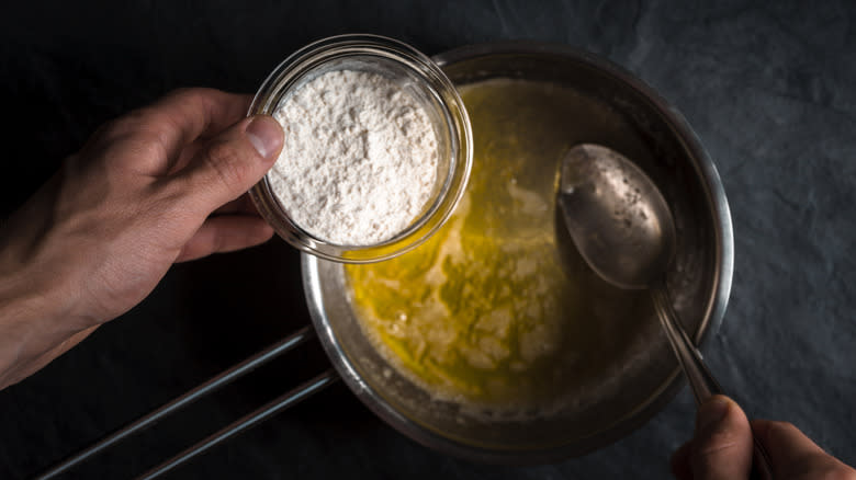 hands adding flour to melted butter