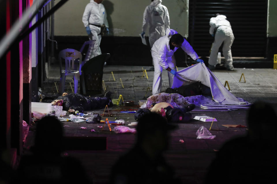 A crime scene worker covers up one of the bodies of victims of a shooting in Garibaldi Plaza, in Mexico City, Friday Sept. 14, 2018. Mexican authorities say four people have been killed and nine wounded in a shooting at the capital’s emblematic Garibaldi Plaza, a popular spot for tourists. (AP Photo/Stringer)