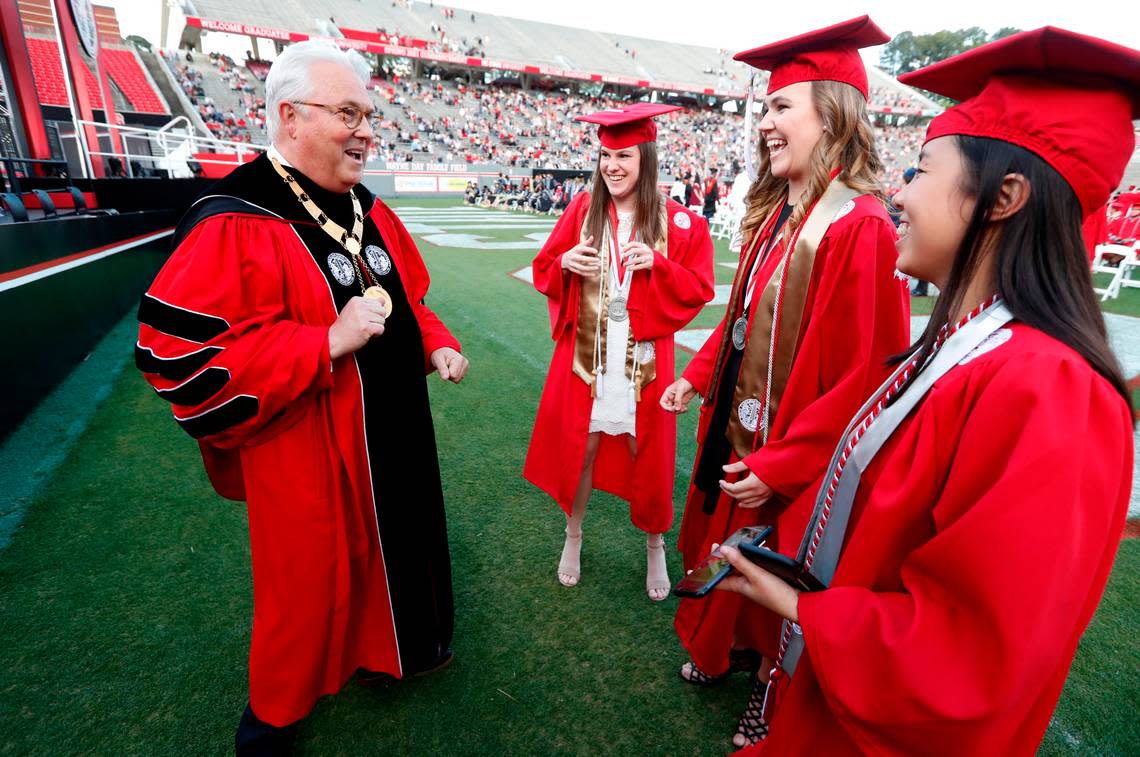 Chancellor Randy Woodson laughs with Kathryn Carter, center left, Kylee Redmond and Emma Langston, right, before N.C. State’s commencement ceremonies for the class of 2021 at Carter-Finley Stadium in Raleigh, N.C., Friday, May 14, 2021.