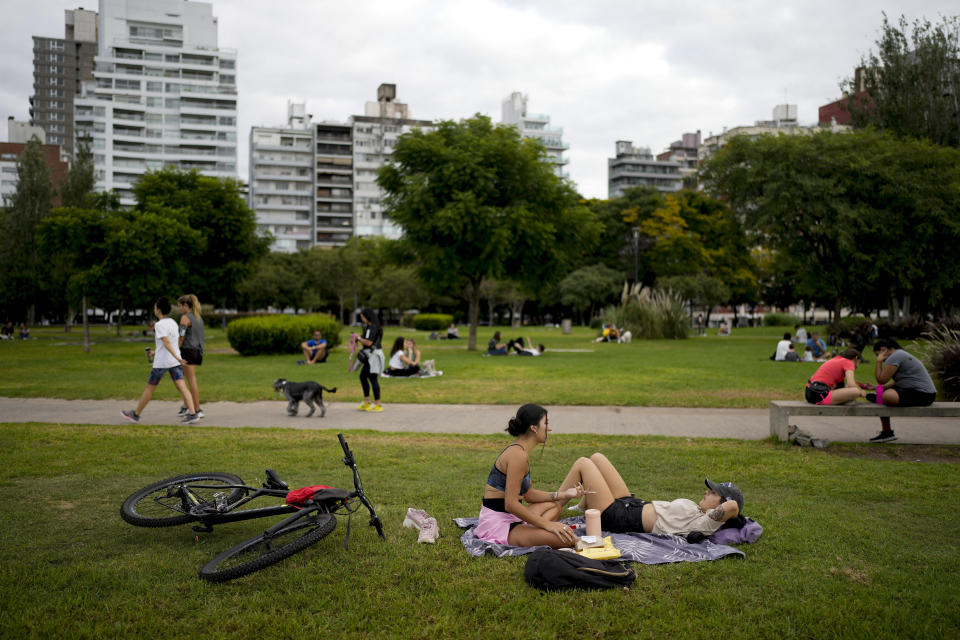 People hang out at a park in Rosario, Argentina, Monday, April 8, 2024. The birthplace of Lionel Messi and revolutionary Ernesto “Che” Guevara morphed about a decade ago into the country’s drug trafficking hub, as regional crackdowns pushed the trade south. (AP Photo/Natacha Pisarenko)