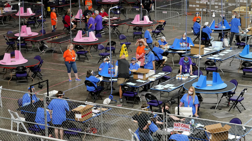 In this May 6, 2021 file photo, Maricopa County ballots cast in the 2020 general election are examined and recounted by contractors working for Florida-based company, Cyber Ninjas at Veterans Memorial Coliseum in Phoenix.  (Matt York/AP Photo)