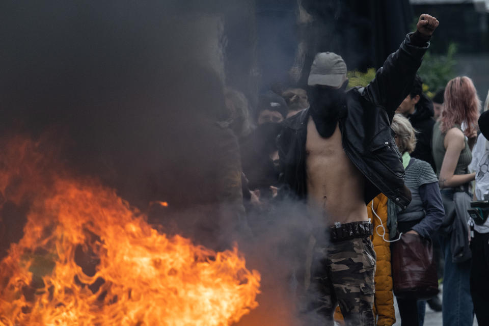 A protester in front of a fire during a demonstration on a national action day, a week after the government pushed a pensions reform through parliament without a vote, using the article 49.3 of the constitution, in Bordeaux, southwestern France, on March 23, 2023. French President defiantly vowed to push through a controversial pensions reform on March 22, 2023, saying he was prepared to accept unpopularity in the face of sometimes violent protests. (Photo by Jerome Gilles/NurPhoto via Getty Images)