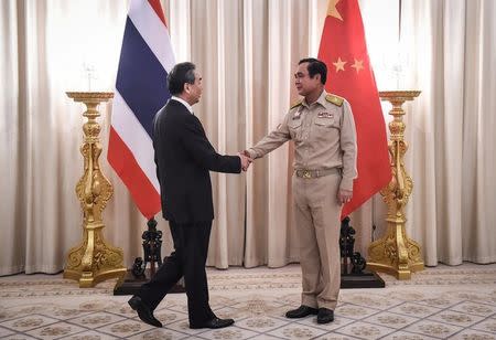 Chinese Foreign Minister Wang Yi (L) is received by Thai Prime Minister Prayuth Chan-O-Cha (R) at Government House in Bangkok, Thailand July 24, 2017. REUTERS/Lillian Suwanrumpha/Pool