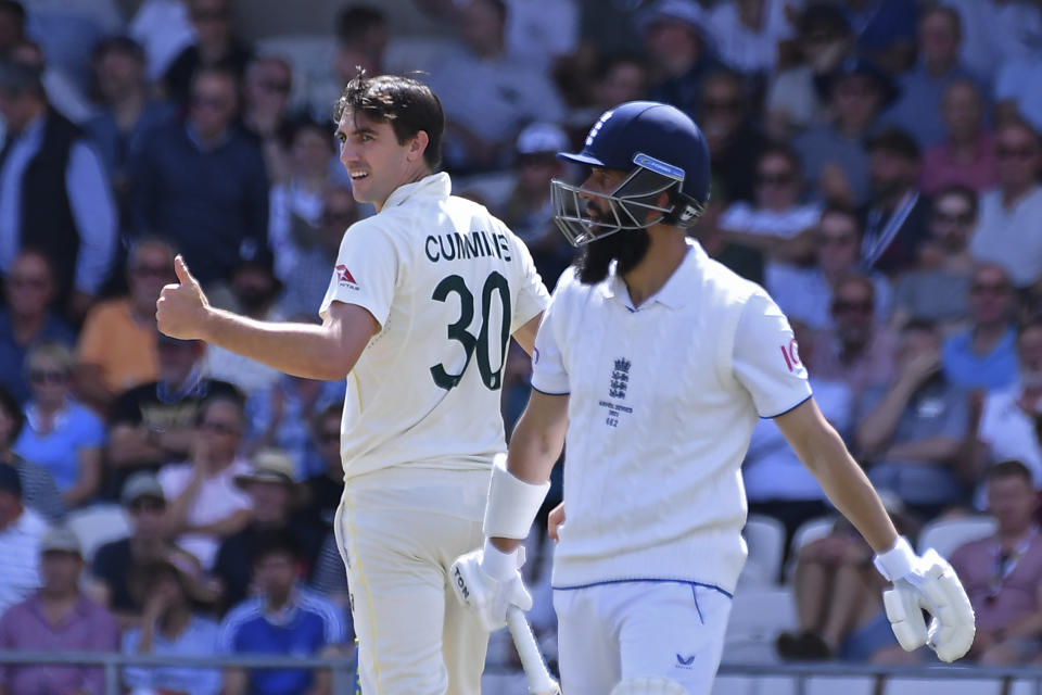 Australia's captain Pat Cummins, left, celebrates the dismissal of England's Moeen Ali, right, during the second day of the third Ashes Test match between England and Australia at Headingley, Leeds, England, Friday, July 7, 2023. (AP Photo/Rui Vieira)