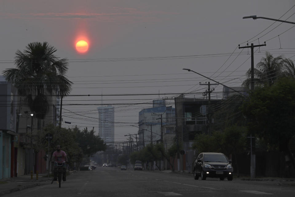 The sun, dimmed by the pall of smoke that cover the city, rises in the city of Porto Velho, Rondonia state, Brazil, Saturday, Aug. 24, 2019. Brazil says military aircraft and 44,000 troops will be available to fight fires sweeping through parts of the Amazon region. The defense and environment ministers have outlined plans to battle the blazes that have prompted an international outcry as well as demonstrations in Brazil against President Jair Bolsonaro's handling of the environmental crisis. (AP Photo/Eraldo Peres)