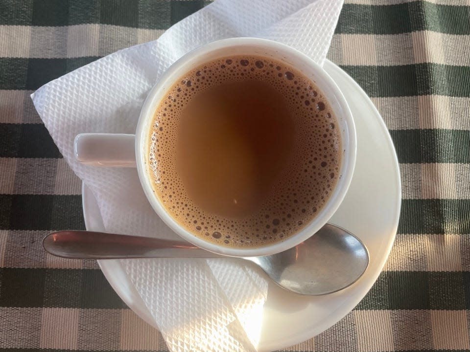 Cup of tea on checkered tablecloth 