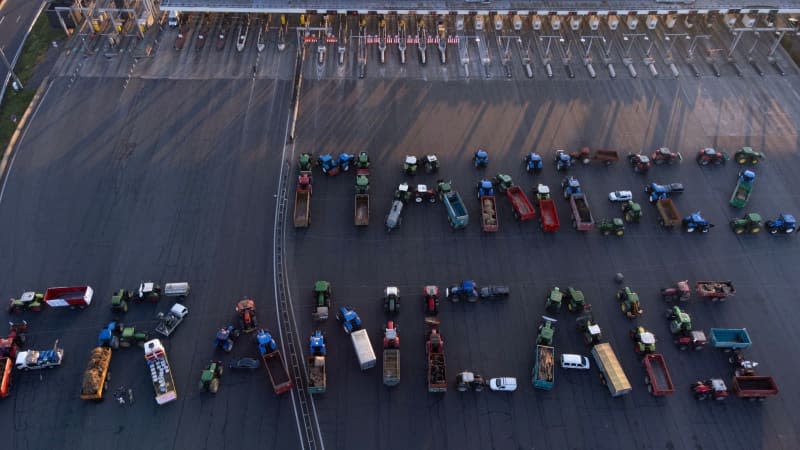 An aerial shot shows farmers forming the slogan "mangez Francais" ('eat French') with their vehicles as they block the A6 highway toll of Villefranche-Limas, amid nationwide protests called by several farmers unions on pay, tax and regulations. Hassan Ayadi/AFP/dpa