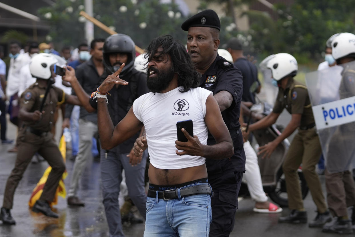 Sri Lankan police detain an anti-government protester during clashes in Colombo, Sri Lanka, Monday, May 9, 2022. Authorities deployed armed troops in the capital Colombo on Monday hours after government supporters attacked protesters who have been camped outside the offices of the country's president and prime minster, as trade unions began a “Week of Protests” demanding the government change and its president to step down over the country’s worst economic crisis in memory. (AP Photo/Eranga Jayawardena)