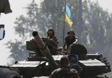 Ukrainian soldiers look out from a tank at a position some 60 km from the eastern Ukrainian city of Donetsk, July 10, 2014. Ukrainian forces regained more ground but sustained further casualties on Thursday in clashes with separatists, while two Western allies urged Russia's Vladimir Putin to exert more pressure on the rebels to find a negotiated end to the conflict. REUTERS/Gleb Garanich