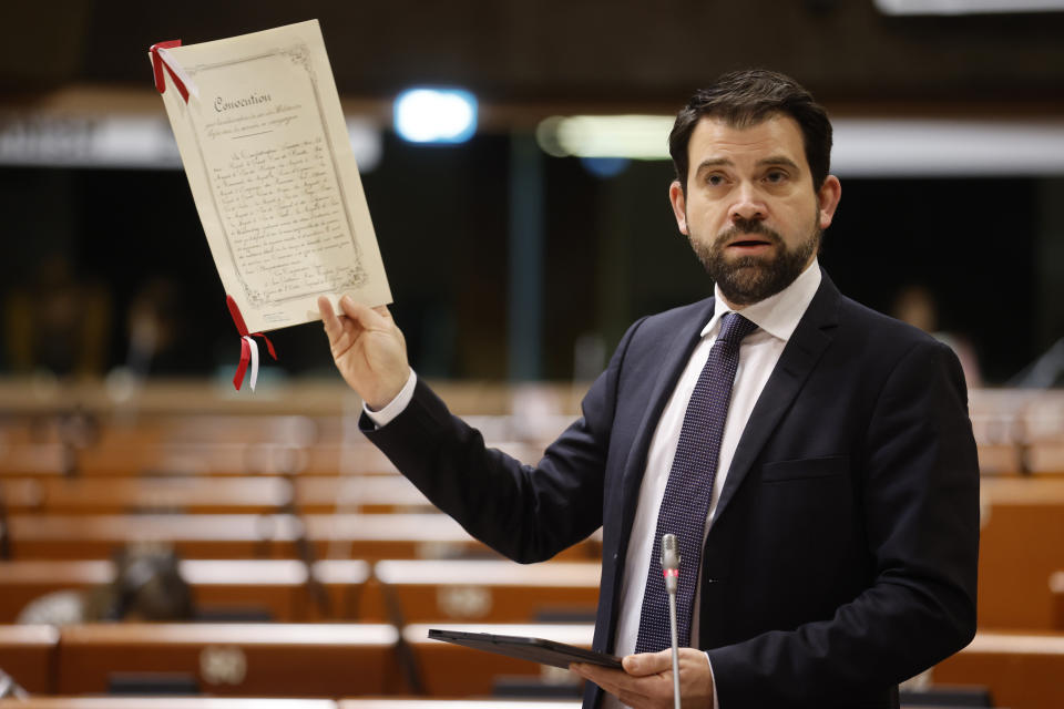 Swiss speaker Damien Cottier holds the Geneva Convention on international legal standards for humanitarian treatment in war during a session at the Council of Europe Parliamentary Assembly (PACE) in Strasbourg, eastern France, Thursday, Jan.26, 2023. The Council of Europe Parliamentary Assembly is holding an urgent debate on the legal and human rights aspects of the Russian's aggression against Ukraine. (AP Photo/Jean-Francois Badias)