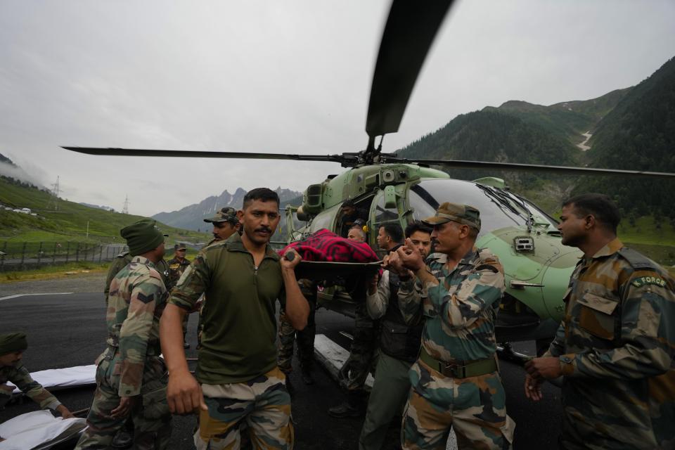 Indian army soldiers carry an injured of a cloudburst for treatment, at Baltal, 105 kilometers (65miles) northeast of Srinagar, Indian controlled Kashmir, Saturday, July 9, 2022. At least eight pilgrims have been killed after a cloudburst triggered a flash flooding during an annual Hindu pilgrimage to an icy Himalayan cave in Indian-controlled Kashmir. Officials say the cloudburst near the hollowed mountain cave revered by Hindus on Friday sent a wall of water down a mountain gorge and swept about two dozen encampments and two makeshift kitchens. (AP Photo/Mukhtar Khan)