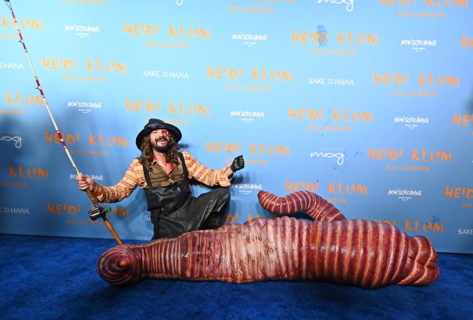 Heidi Klum wears a worm costume at her 21st annual Halloween Party, as her husband Tom Kaulitz plays along as a fisherman.