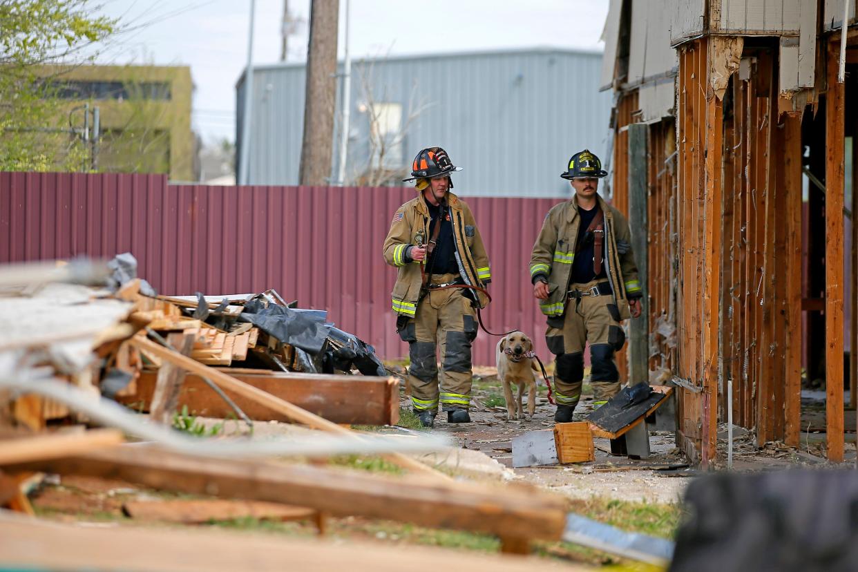 Oklahoma City firefighters walk with a search and rescue dog beside the second story of a collapsed building on the corner of NW 39 and Pennsylvania Ave. in Oklahoma City in April 2021. On Monday, Oklahoma County Commissioners declined to take action on an agenda item to support spending $25 million in coronavirus relief funds on a new search and rescue dog training facility.