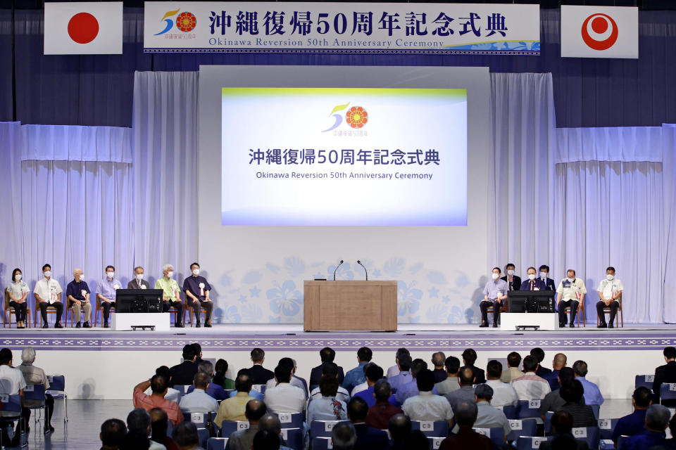 Japan's Prime Minister Fumio Kishida, sixth right, and Okinawa Gov. Denny Tamaki, fourth right, attend a ceremony to mark the 50th anniversary of Okinawa's return to Japan after 27 years of American rule, in Ginowan, Okinawa prefecture, Japan Sunday, May 15, 2022. (Kyodo News via AP)