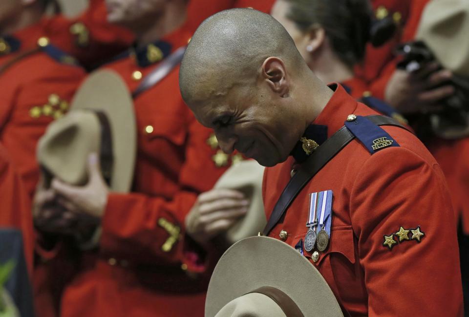 A Royal Canadian Mounted Police officer reacts during the regimental funeral for three fellow officers who were killed last week in Moncton