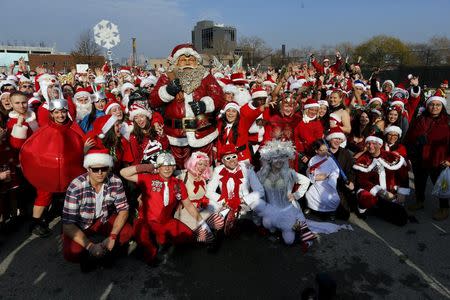 Revelers dressed in Santa Claus and other holiday themed outfits pose for a group photo before the start of the annual SantaCon event in the Brooklyn borough of New York, December 12, 2015. REUTERS/Brendan McDermid