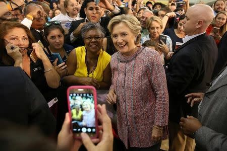 U.S. Democratic presidential nominee Hillary Clinton poses with fans after talking about climate change with Vice President Al Gore at a rally at Miami Dade College in Miami, Florida, U.S. October 11, 2016. REUTERS/Lucy Nicholson