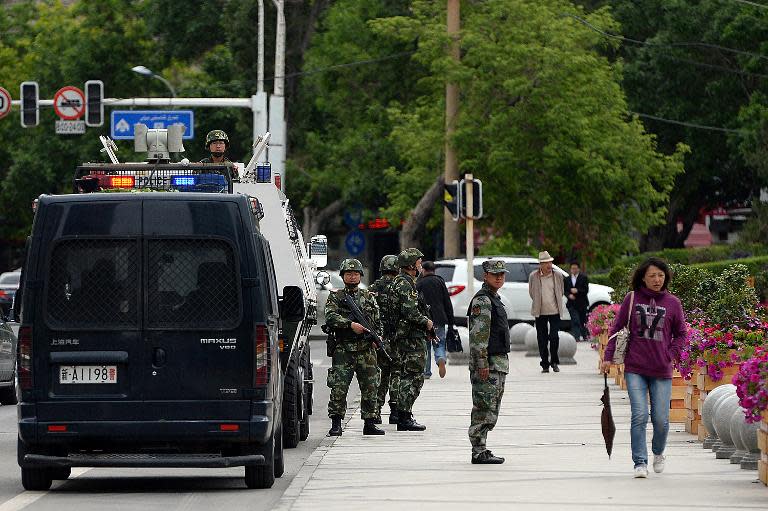 Chinese paramilitary police officers stand guard along a street in Urumqi, the capital of western China's Muslim Uighur homeland of Xinjiang, on May 23, 2014