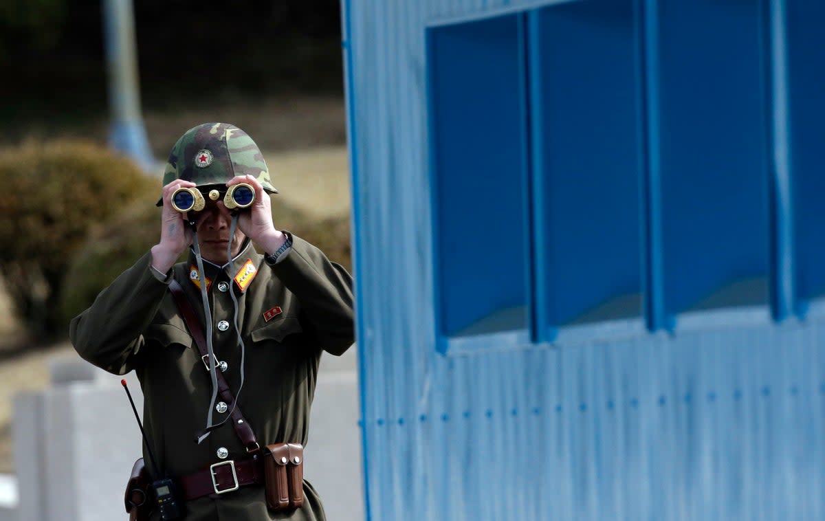 A North Korean soldier looks into the South at the border village of Panmunjom. Defections into the North are rare (AP)