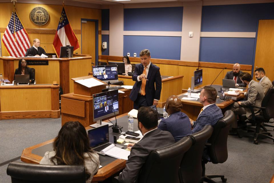 Brian Rafferty, center, attorney for Sidney Powell, gestures to the prosecution team as he addresses the court during a motions hearing in front of Fulton County Superior Court Judge Scott McAfee, top left, in Atlanta, Thursday, Oct. 5, 2023. Nineteen people, including former President Donald Trump, were indicted in August and accused of participating in a wide-ranging illegal scheme to overturn the results of the 2020 presidential election. (Erik S. Lesser/Pool Photo, via AP)