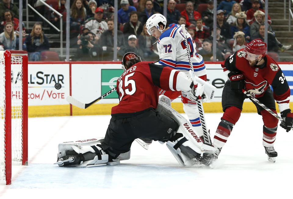 New York Rangers center Filip Chytil (72) attempts to shoot the puck past Arizona Coyotes goalie Darcy Kuemper (35) as Arizona Coyotes' Alex Goligoski (33) defends during the second period of an NHL hockey game, Sunday, Jan. 6, 2019, in Glendale, Ariz. (AP Photo/Ralph Freso)