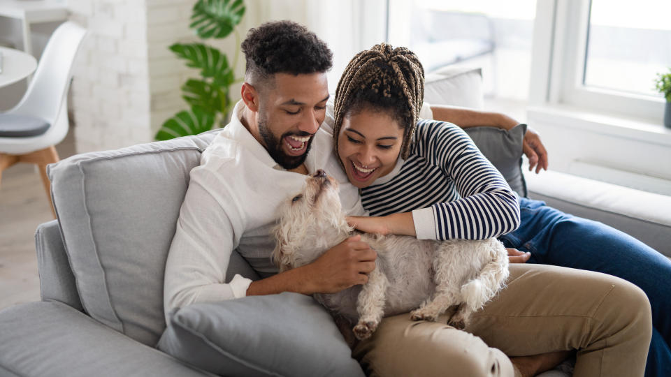 Couple smiling cuddling dog