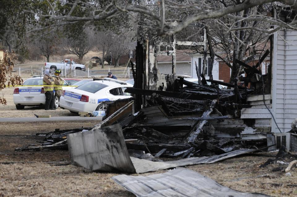 Mike Lawrence/The Gleaner Fire investigators work at the scene of early morning house fire near Greenville, Ky., Thurday Jan. 1, 2014. Nine people from a family of eleven are presumed dead in the fire. (AP Photo/The Gleaner, Mike Lawrence)