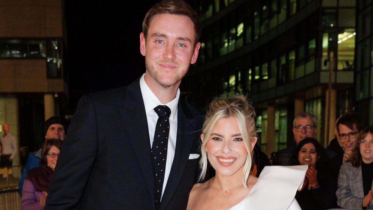 Stuart Broad in a suit with fiancee Mollie King in a white one-shouldered dress