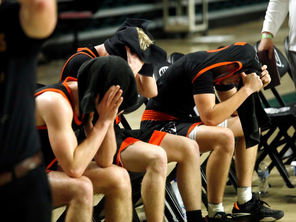 New Lexington's Jerek Braglin, left, Bentley Hanson and Isaiah Stephens sit on the bench following a 54-46 overtime loss to Vincent Warren on Saturday in a Division II district final at the Ohio Convocation Center in Athens. The Panthers finished a 21-5 season that fell one win shy of its first regional appearance since 1998.