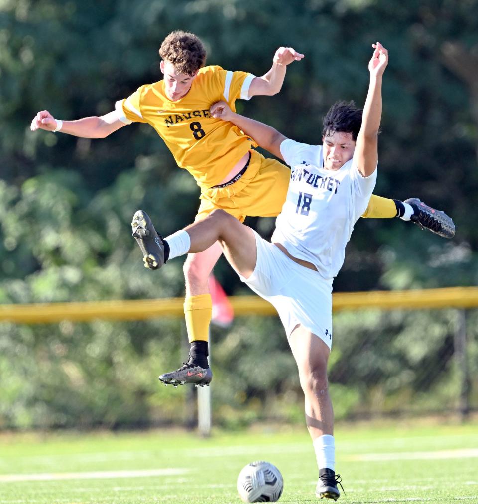 In this Sept. 19, 2023 photo Denzel Tajada of Nantucket and Devin Farrell of Nauset fly through the air attempting to control the ball.