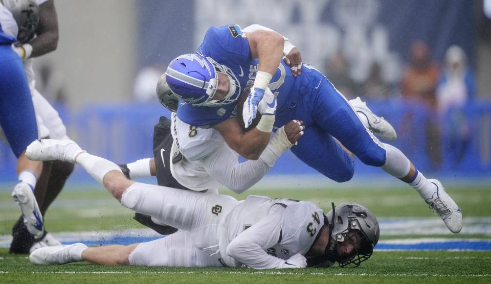 Air Force running back Brad Roberts, top right, is stopped after a short gain by Colorado linebacker Josh Chandler-Semedo and safety Trevor Woods in the first half of an NCAA college football game Saturday, Sept. 10, 2022, at Air Force Academy, Colo. (AP Photo/David Zalubowski)