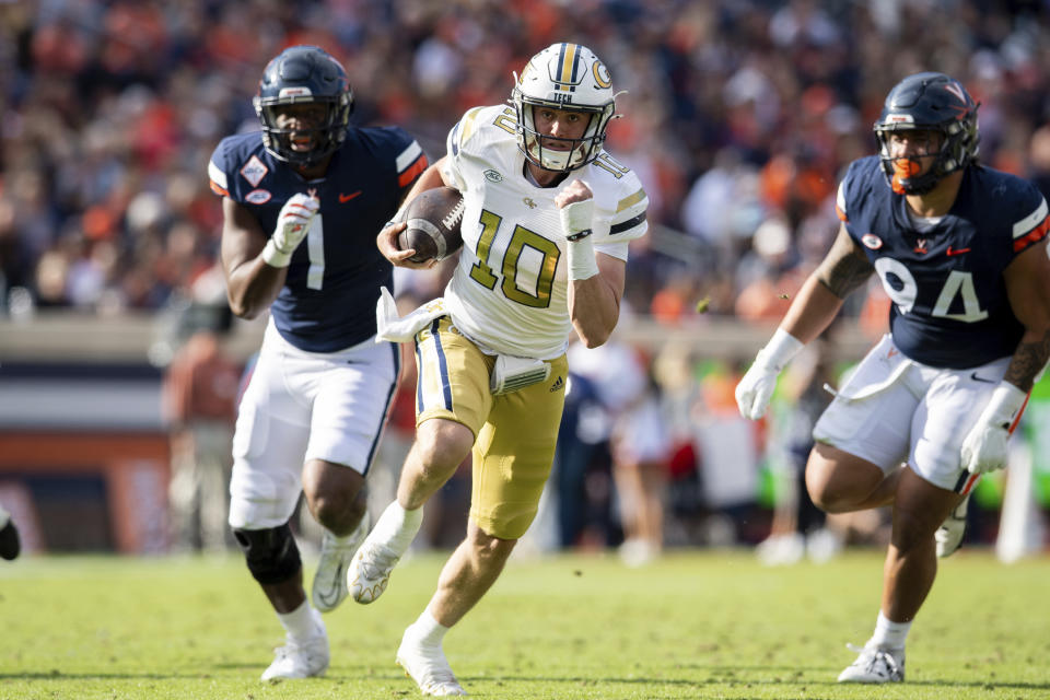 Georgia Tech quarterback Haynes King (10) runs for a touchdown as he is pursued by Virginia defensive end Paul Akere (1) and defensive tackle Aaron Faumui (94) during the first half of an NCAA college football game Saturday, Nov. 4, 2023, in Charlottesville, Va. (AP Photo/Mike Caudill)