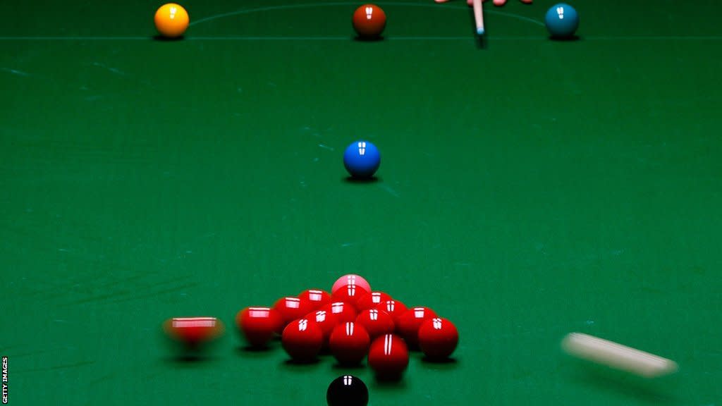 A view of a snooker table after the cue ball hits the reds