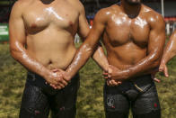 Wrestlers, doused in olive oil, greet each other as they are introduced to the crowds during the 660th instalment of the annual Historic Kirkpinar Oil Wrestling championship, in Edirne, northwestern Turkey, Saturday, July 10, 2021. Thousands of Turkish wrestling fans flocked to the country's Greek border province to watch the championship of the sport that dates to the 14th century, after last year's contest was cancelled due to the coronavirus pandemic. The festival, one of the world's oldest wrestling events, was listed as an intangible cultural heritage event by UNESCO in 2010. (AP Photo/Emrah Gurel)