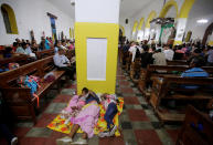 <p>Hondurans fleeing poverty and violence rest in the local church after a long walk, part of their journey in a caravan to the United States, in Ocotepeque, Honduras, Oct. 14, 2018. (Photo: Jorge Cabrera/Reuters) </p>