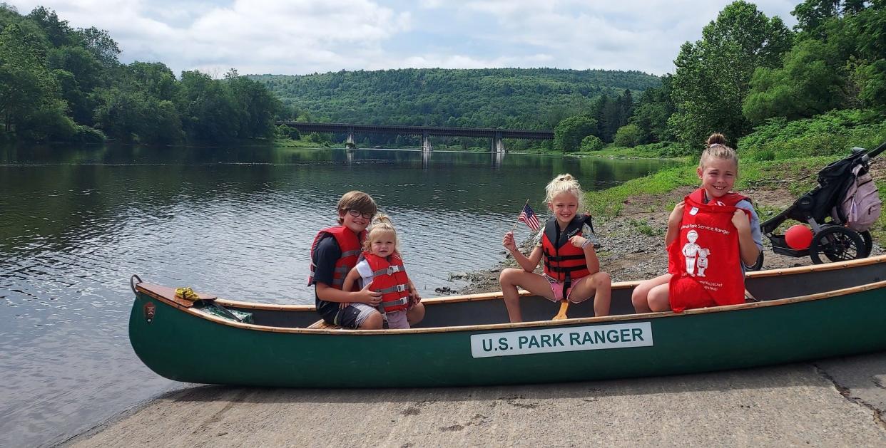 Getting caught isn’t always a bad thing: Park rangers caught this family wearing life jackets in Lackawaxen, Pa., on July 3 and rewarded them with T-shirts. The Roebling Bridge is in the background spanning the Upper Delaware. The National Park Service stresses the need to wear life jackets to protect from drowning.