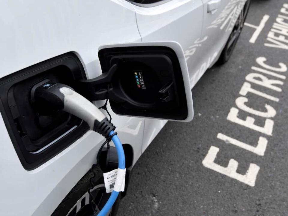An electric car is charged at a roadside EV charge point in London on Oct. 19. In Canada, Windsor, Ont., is getting the country&#39;s first electric vehicle battery plant, it was announced Wednesday. (Toby Melville/Reuters - image credit)