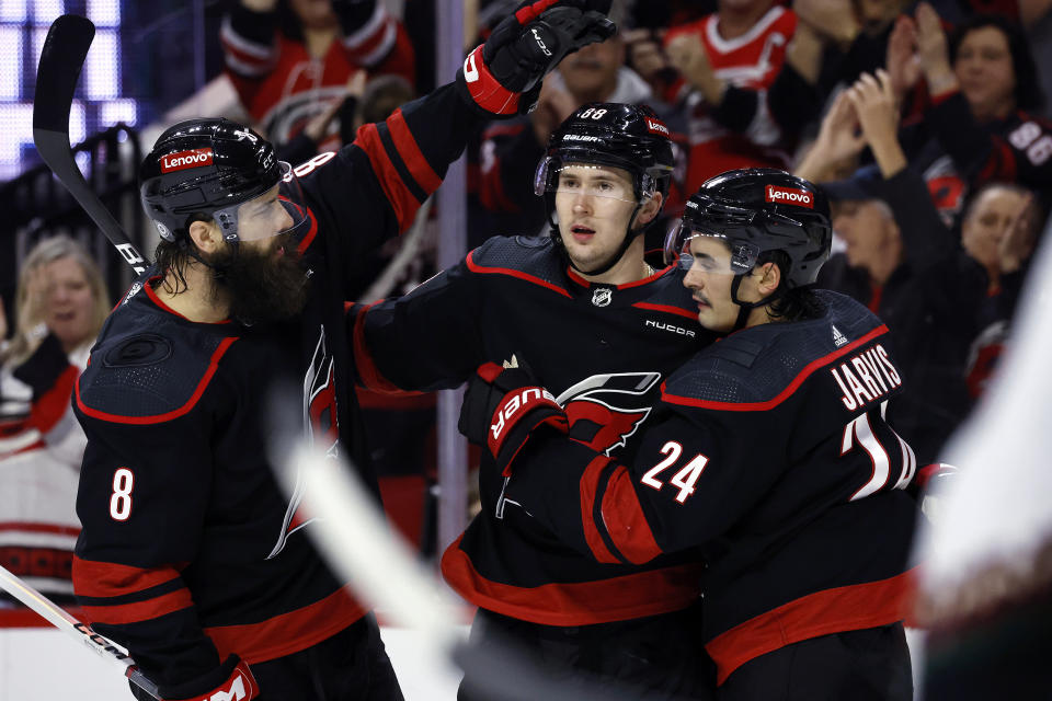 Carolina Hurricanes' Martin Necas, center, celebrates his goal against the Arizona Coyotes with Brent Burns (8) and Seth Jarvis (24) during the second period of an NHL hockey game Saturday, Jan. 27, 2024, in Raleigh, N.C. (AP Photo/Karl B DeBlaker)