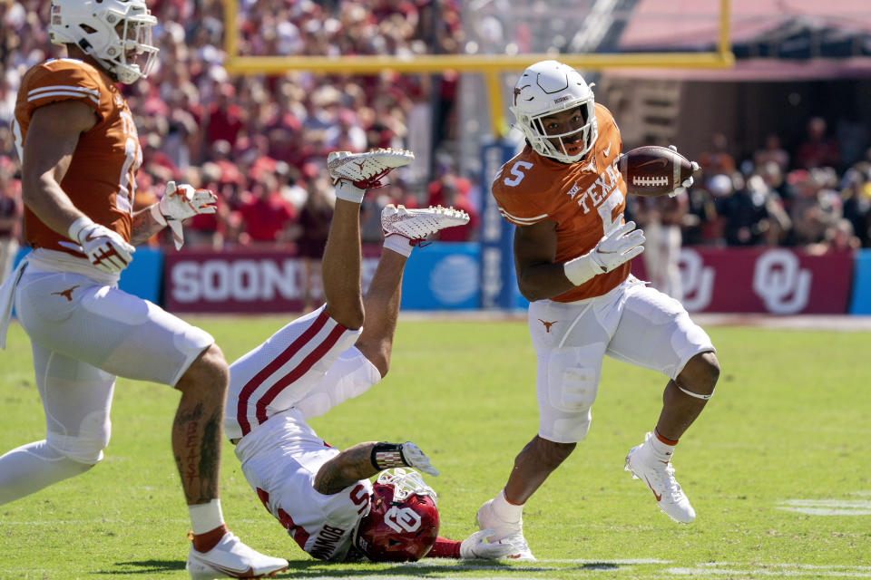 Texas running back Bijan Robinson (5) runs past Oklahoma defensive back Billy Bowman (5) during the first half of an NCAA college football game at the Cotton Bowl, Saturday, Oct. 9, 2021, in Dallas. (AP Photo/Jeffrey McWhorter)