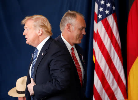 U.S. President Donald Trump walks past Interior Secretary Ryan Zinke as he stands to address the 17th annual September 11 observance at the Flight 93 National Memorial near Shanksville, Pennsylvania, U.S., September 11, 2018. REUTERS/Kevin Lamarque