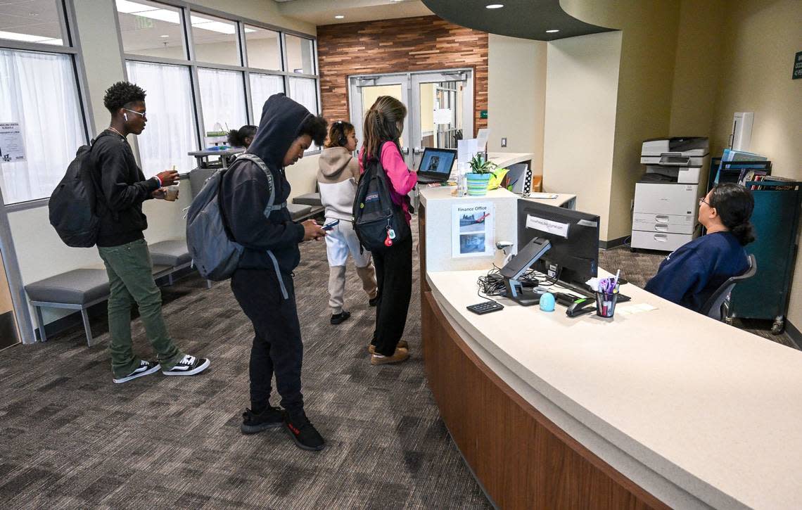 Students stand at the counter of the newly renovated Hoover High School library which now includes a campus culture room, student store, career center, counseling center, and social services support center.