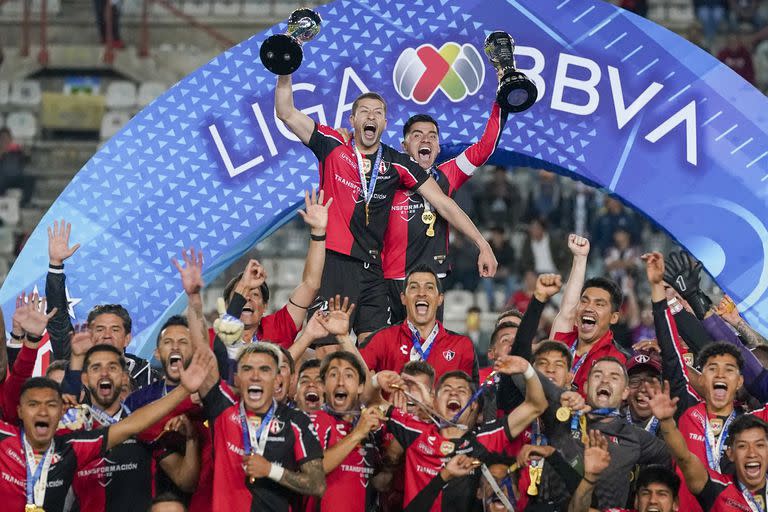 Los futbolistas de Atlas levantan los trofeos luego de consagrarse bicampeones de la Liga de México este domingo