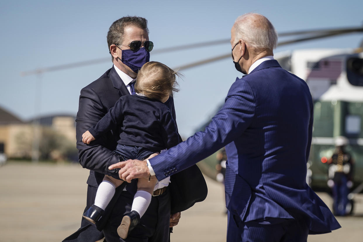 President Joe Biden talks with his son Hunter Biden as he holds his grandson Beau Biden as they walk to board Air Force One at Andrews Air Force Base, Md., on March 26, 2021. (Patrick Semansky / AP file)