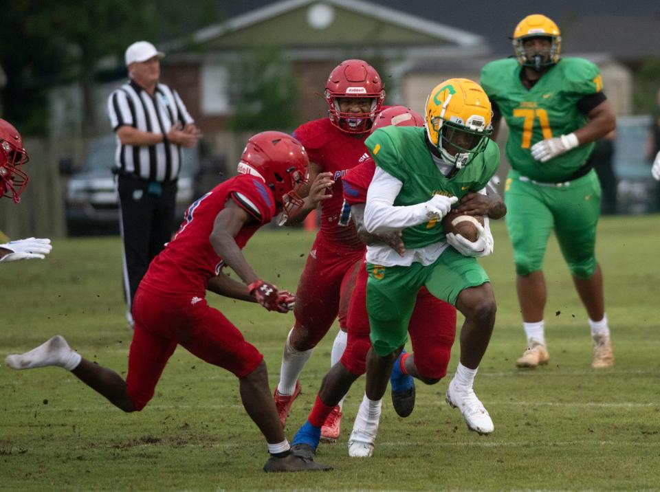 Catholic's Koby Howard (No. 1) fights off tackles as he runs the open field during Wednesday's Spring football game against Pine Forest. 