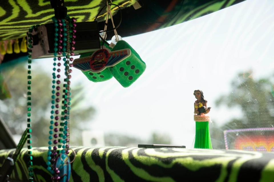 Accessories like fuzzy dice, a hula girl and Mardi Gras beads decorate a car at Cruise Central at Centennial Plaza during Cruisin’ the Coast.