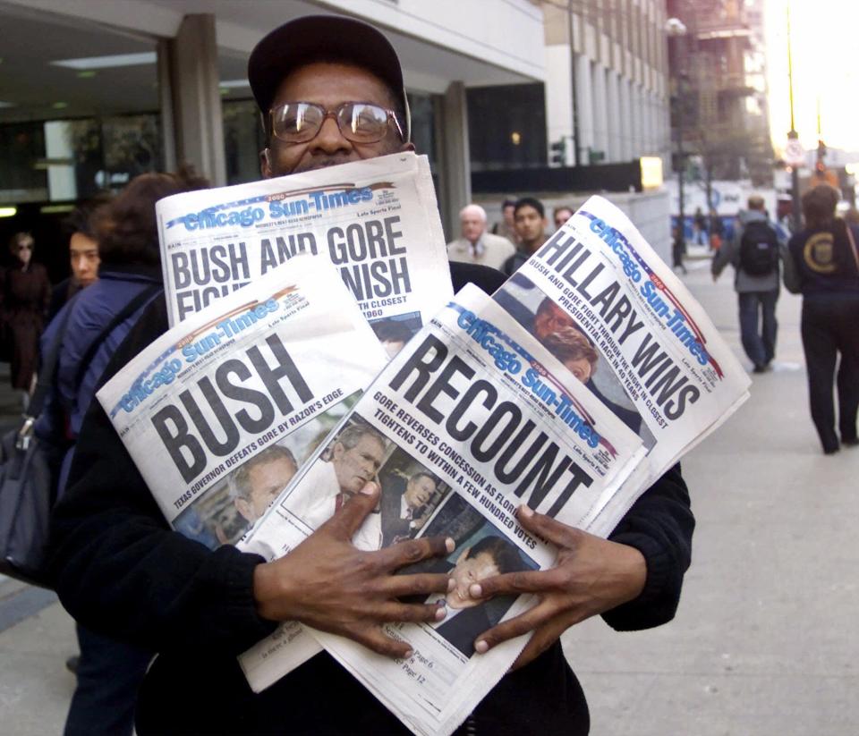 In this Nov. 8, 2000 file photo, Willie Smith holds four copies of the Chicago Sun-Times, each with a different headline, in Chicago, reflecting a night of suspense, drama and changes in following the presidential race between Vice President Al Gore and Texas Gov. George W. Bush.