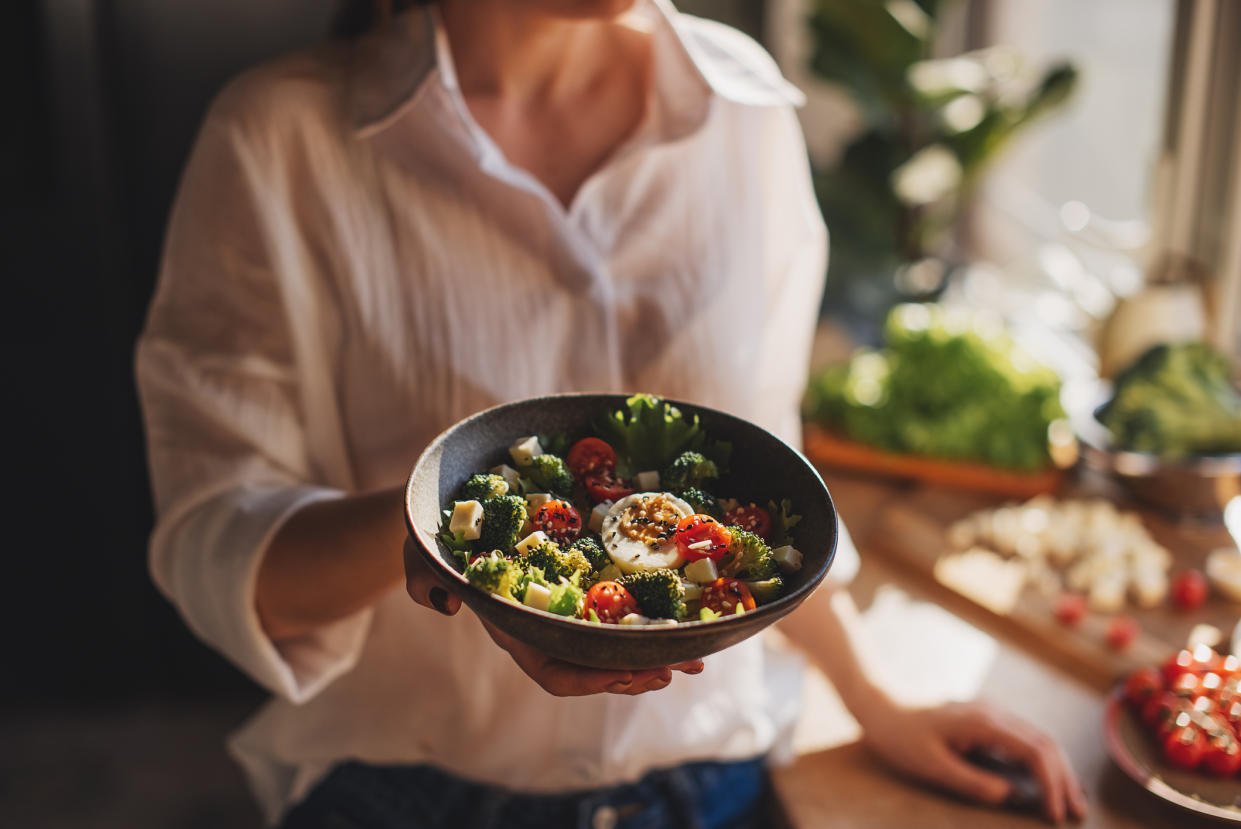 Woman revealing a bowl of food, with reduced calories. (Getty Images)