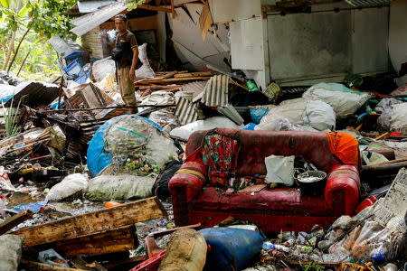 A man pauses as he stands next to debris at his house which was hit by the tsunami in Pandeglang, Banten province, Indonesia, December 24, 2018. REUTERS/Jorge Silva