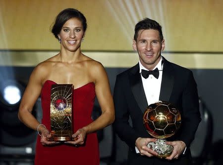 FC Barcelona's Lionel Messi of Argentina (R) poses with Houston Dash's Carli Lloyd of the U.S. with their World Player of the Year awards during the FIFA Ballon d'Or 2015 ceremony in Zurich, Switzerland, January 11, 2016. REUTERS/Arnd Wiegmann