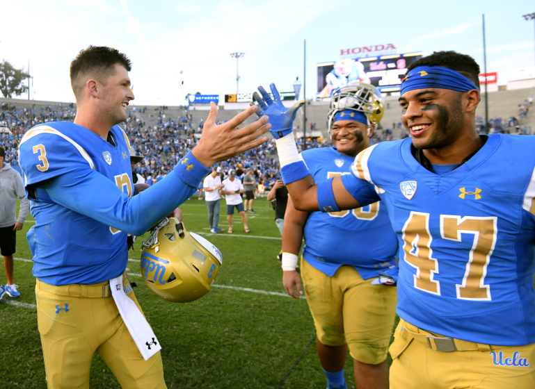 PASADENA, CALIFORNIA - NOVEMBER 17: Wilton Speight #3 of the UCLA Bruins celebrates with Shea Pitts.